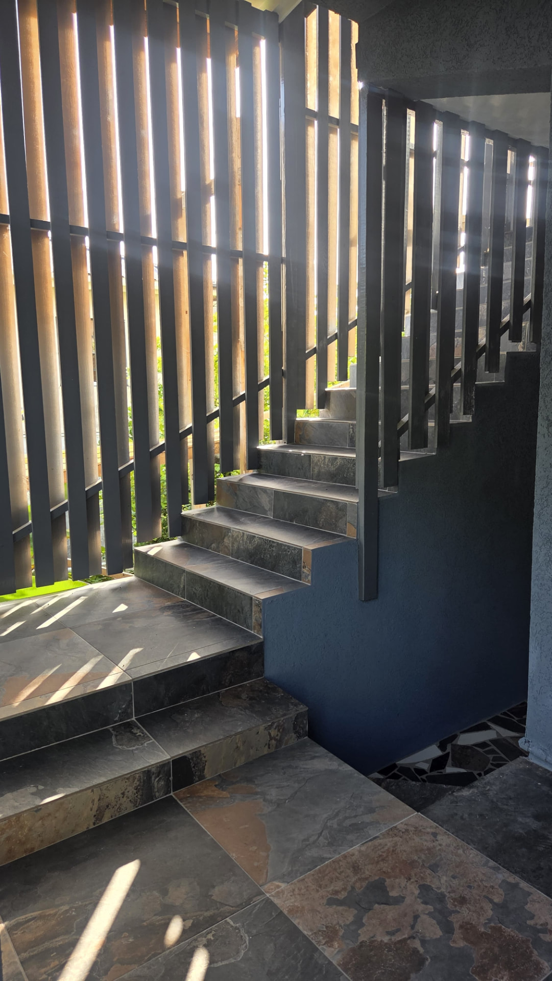 Stone-tiled entry landing with slatted screen