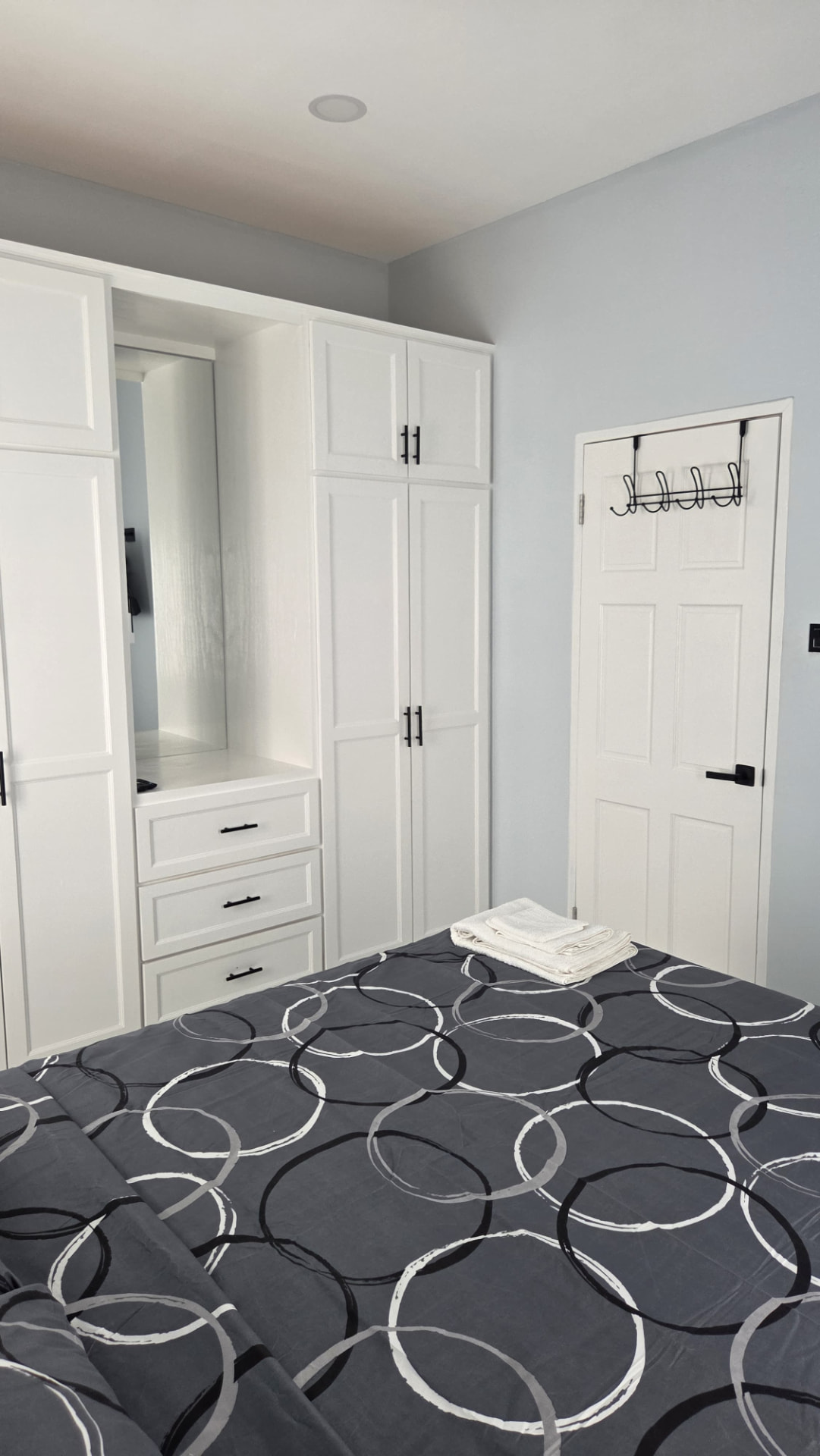 Wardrobe drawers and mirror beside the bedroom door